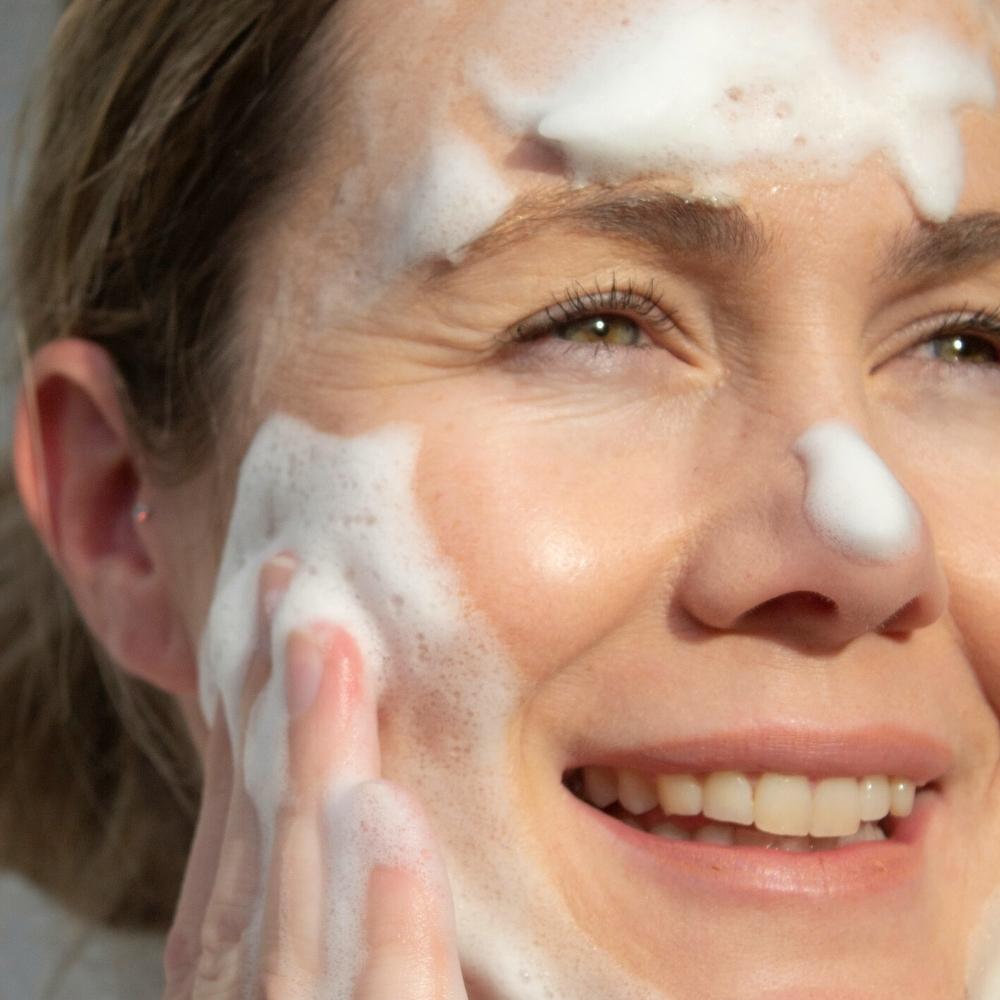 Woman applying foaming cleanser