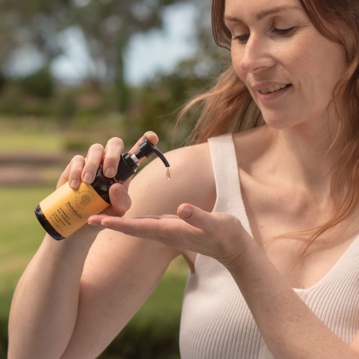Woman pumping Vitamin C Vitamin C Gel Cleanser into palm of her hand
