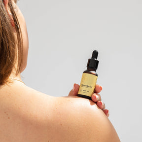 Woman holding bottle of ManukaRx Dry Skin Oil